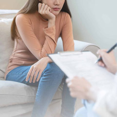 Young woman in a mental therapy session talking with a psychologist in the office.