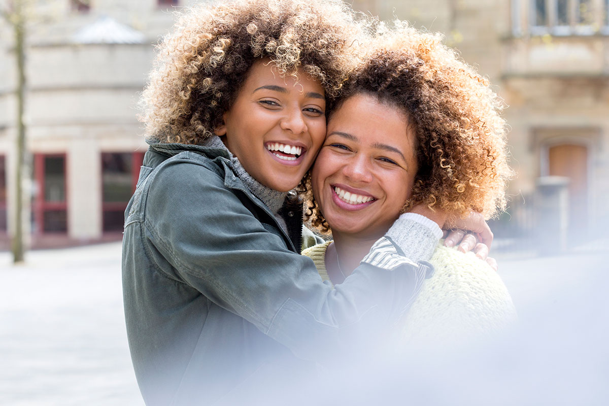 Two happy women embrace